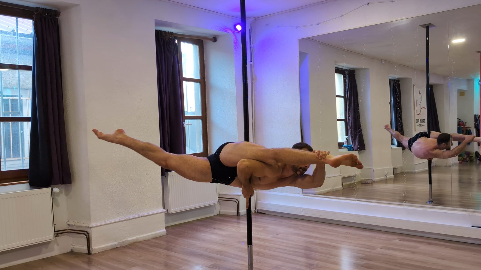 Vincent Regnault en Machine gun à la barre de pole dance, grand écart latéral